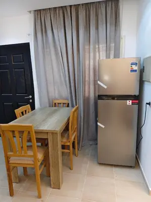 a kitchen with a wooden table and a refrigerator at Nobia Aqua Beach in Hurghada