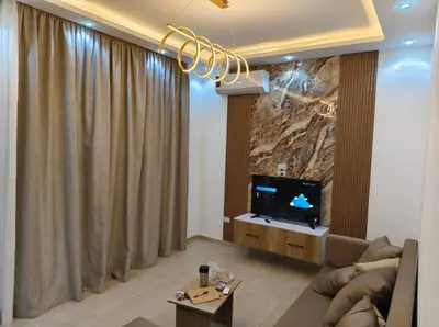 a living room with a couch and a tv at Nobia Aqua Beach in Hurghada