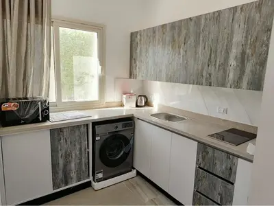 a kitchen with a washing machine and a window at Nobia Aqua Beach in Hurghada