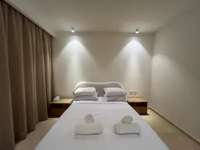 a bedroom with a white bed with two towels on it at Ancient Sands 2BR | Ground Floor, Pool Access in Hurghada