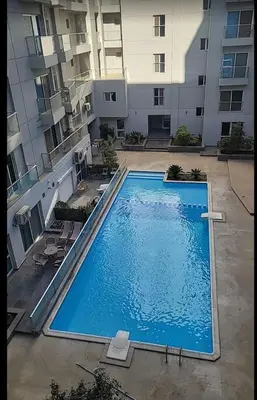 a large swimming pool in front of a building at One bedroom apartment in center of the city in Hurghada