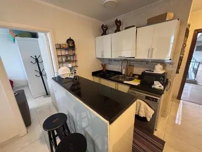 a kitchen with white cabinets and a black counter top at One bedroom apartment in center of the city in Hurghada