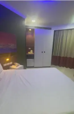a bedroom with a large white bed and a kitchen at مول بلازا in Aswān