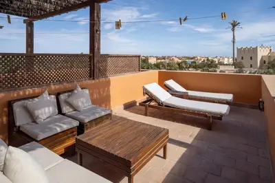 a patio with a couch and chairs on a roof at South Marina Central 2BR, bathtub, Terraces & Pool in Hurghada