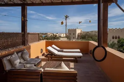 a balcony with lounge chairs and a view of a city at South Marina Central 2BR, bathtub, Terraces & Pool in Hurghada