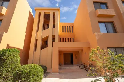 an orange building with bikes parked in front of it at South Marina Central 2BR, bathtub, Terraces & Pool in Hurghada