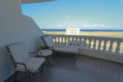 two chairs on a balcony with a view of an airport at 36 Southwalk in Quseir