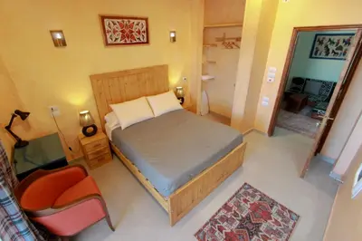 a small bedroom with a bed and a chair at 36 Southwalk in Quseir