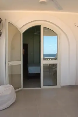 a room with a sliding glass door with a view of the ocean at 36 Southwalk in Quseir