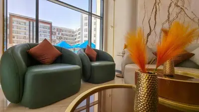 a living room with two green chairs and a table at Tiba golden resort in Hurghada