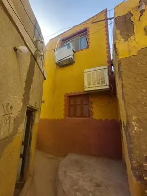 an alley with a yellow building with a window at moon guest house in Jazīrat Aswān