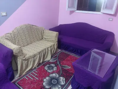 a living room with a chair and a couch at moon guest house in Jazīrat Aswān