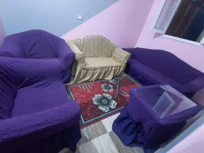 a living room with a purple couch and a chair at moon guest house in Jazīrat Aswān