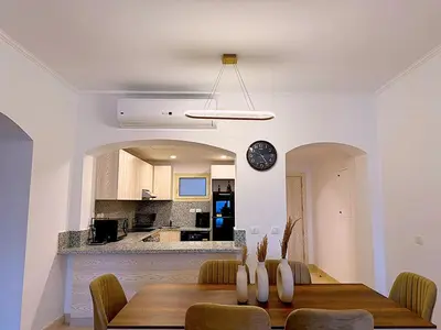 a dining room with a table and a kitchen at Luxury Apartment In Azzurra Sahl Hashish 6G101 in Hurghada