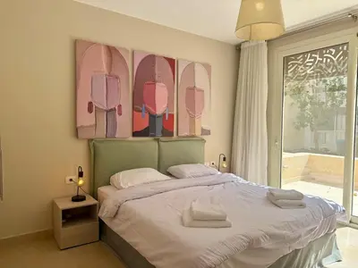 a bedroom with a bed with surfboards on the wall at Bright 1BR Apt - Free Beach And Pool In Mangroovy ElGouna in Hurghada