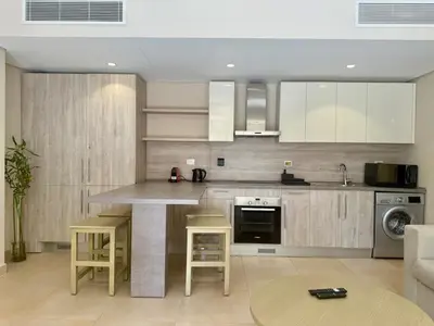 a kitchen with a large island in a room at Bright 1BR Apt - Free Beach And Pool In Mangroovy ElGouna in Hurghada