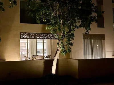 a small tree in front of a building at Bright 1BR Apt - Free Beach And Pool In Mangroovy ElGouna in Hurghada
