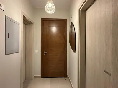 a hallway with a wooden door in a house at Colorful 1BR Apt-Free Pool & Lagoon Access In ElGouna in Hurghada
