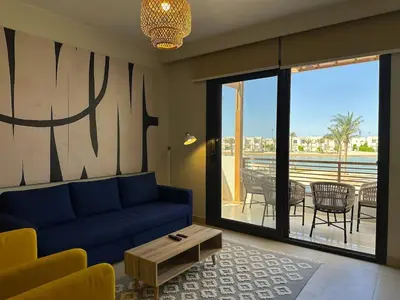 a living room with a blue couch and a table at Colorful 1BR Apt-Free Pool & Lagoon Access In ElGouna in Hurghada