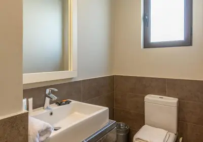 a bathroom with a sink and a toilet and a mirror at Ancient Sands 3BR Twin Villa with a Private Patio Heated Swimming Pool & Lagoon Access in Hurghada
