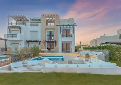 a villa with a swimming pool in front of a house at Ancient Sands 3BR Twin Villa with a Private Patio Heated Swimming Pool & Lagoon Access in Hurghada
