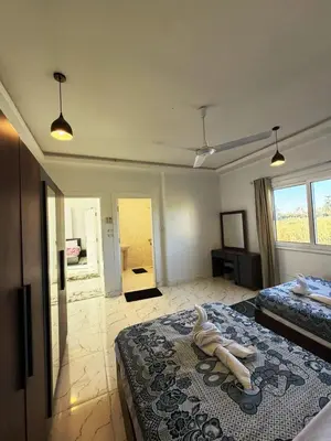 a bedroom with two beds and a room with a doorway at Al Baba II Nile Villa in Luxor