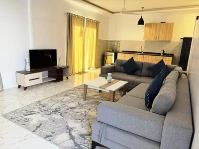 a living room with a couch and a tv at Al Baba II Nile Villa in Luxor