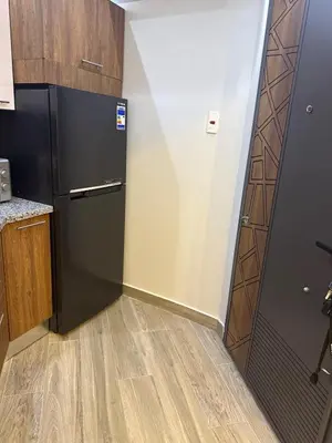 a kitchen with a black refrigerator and a wooden floor at Private Rooftop Two Bedroom SeaView Panorama in Hurghada