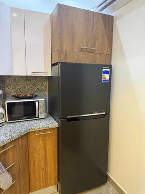 a black refrigerator in a kitchen with a microwave at Private Rooftop Two Bedroom SeaView Panorama in Hurghada