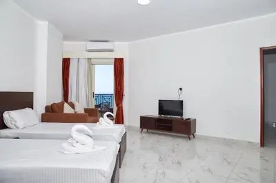 a hotel room with two beds and a television at Juliana beach resort by V in Hurghada