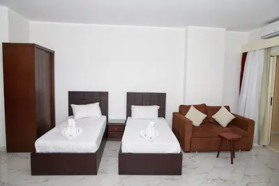 a room with two beds and a couch and a chair at Juliana beach resort by V in Hurghada