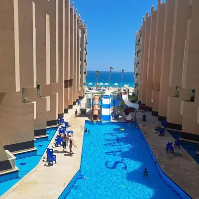 a swimming pool at a resort with people playing in it at Juliana beach resort by V in Hurghada