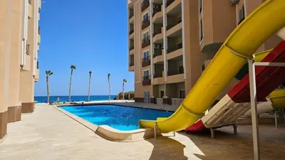 a pool with a slide next to a building at Sea view studio for rent at Juliana at Hurghada in Hurghada