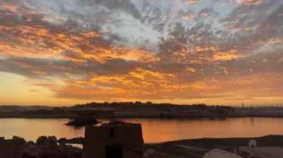 a sunset over a body of water with a building at Safeya Kato in Jazīrat ‘Awwāḑ