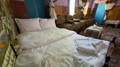 a bedroom with a large bed and a couch at Safeya Kato in Jazīrat ‘Awwāḑ