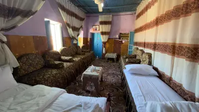 a room with two beds and a couch and chairs at Safeya Kato in Jazīrat ‘Awwāḑ