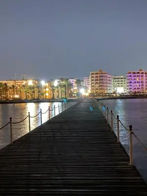 a boardwalk leading into the water at night at Hurghada scandic resort in Hurghada