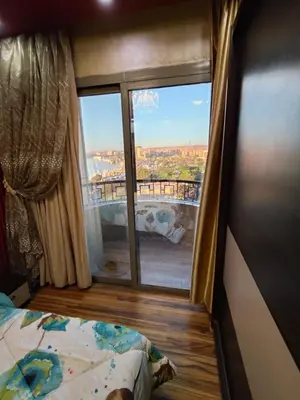 a bedroom with a view of the city from a window at شقة بمول اسوان بلازا- اسوان in Aswān