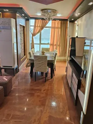 a dining room with a table and a chandelier at شقة بمول اسوان بلازا- اسوان in Aswān