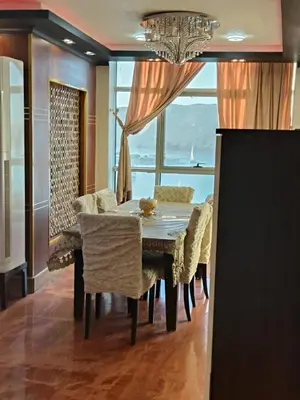 a dining room with a table and chairs and a window at شقة بمول اسوان بلازا- اسوان in Aswān