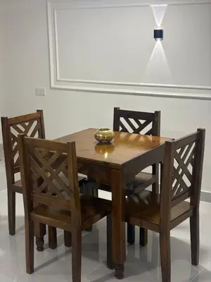 a wooden table with two chairs and a bowl on top at Theban Hills Hotel, Luxor in ‘Ezbet Abu Ḥabashi