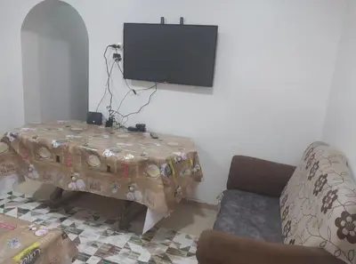 a living room with a table and a flat screen tv at شقة سكنية كبيرة in Aswan