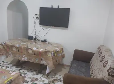 a living room with a table and a flat screen tv at شقة سكنية كبيرة in Aswan