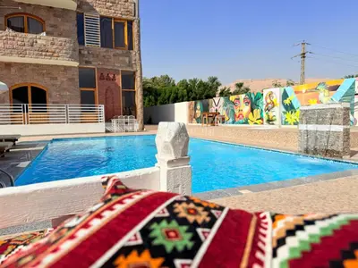 a swimming pool with a blanket in front of a building at Citadel Luxor in Luxor