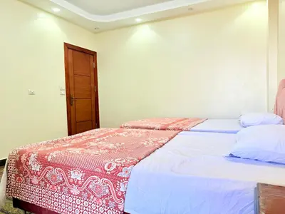 a bedroom with two beds and a door at Sun Palace House in Luxor