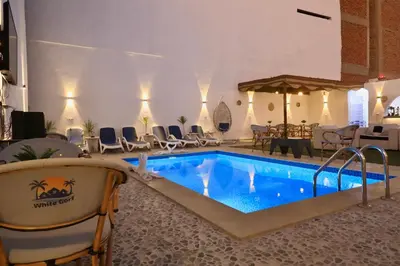 a pool in a hotel with chairs and a table at White Gorf Hotel in Luxor