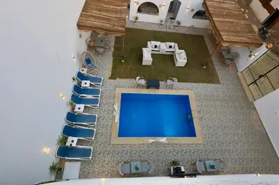 an overhead view of a swimming pool in a resort with chairs and a pool table at White Gorf Hotel in Luxor