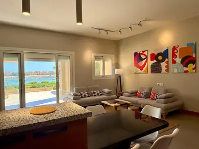 a living room with a couch and a table at Scenic 2BR Ground Floor - Free Pool& Lagoon Access In ElGouna in Hurghada