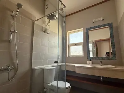 a bathroom with a shower and a toilet and a sink at Scenic 2BR Ground Floor - Free Pool& Lagoon Access In ElGouna in Hurghada