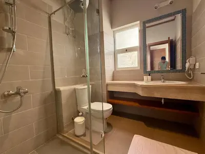 a bathroom with a shower and a toilet and a sink at Scenic 2BR Ground Floor - Free Pool& Lagoon Access In ElGouna in Hurghada